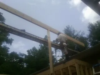 Carpenter setting a ridge beam over a new addition frame — Ice Dam Removal by Roofing Brothers in New Middletown