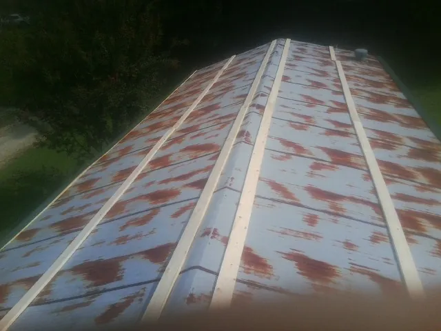 Rusted metal roof panels with new wood purlins before replacement — Storm Damage Roof Repair in New Middletown by Roofing Brothers