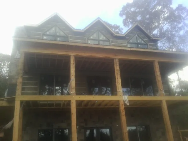 Dormers and porch framing on a large log home under construction — Roof Coating work by our crew in New Middletown