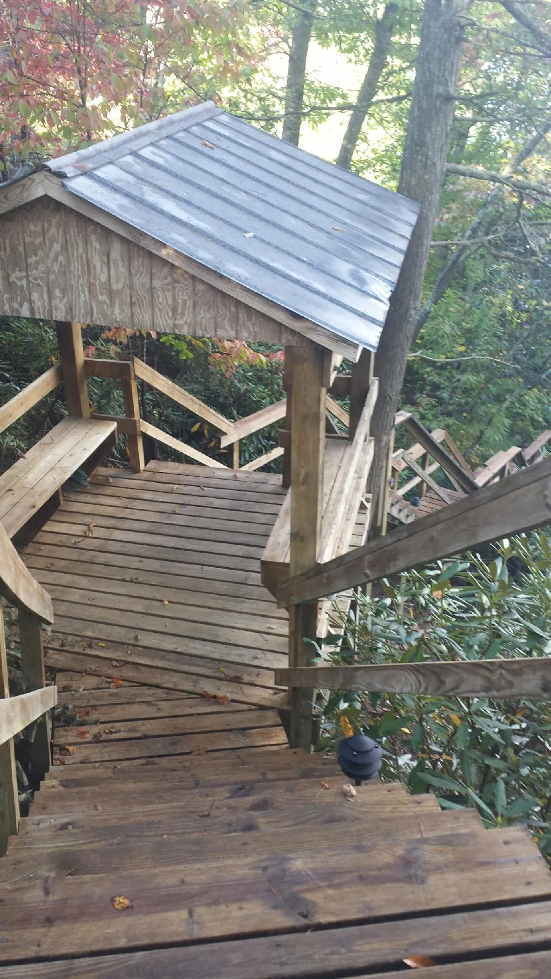 Metal roofed shelter over wooden steps on a wooded walkway — Skylight Repair & Installation work by our crew in New Middletown